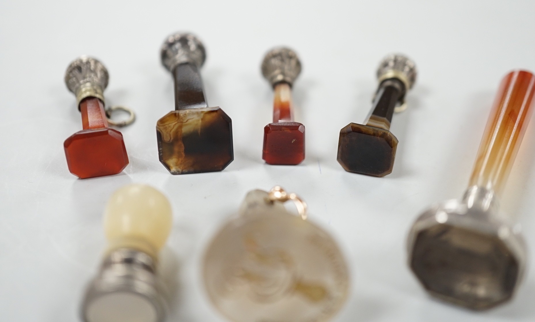 Five assorted 19th century white metal mounted agate seals, largest 61mm, a similar white metal and mother of pearl mounted seal and a white chalcedony seal with monogrammed matrix.